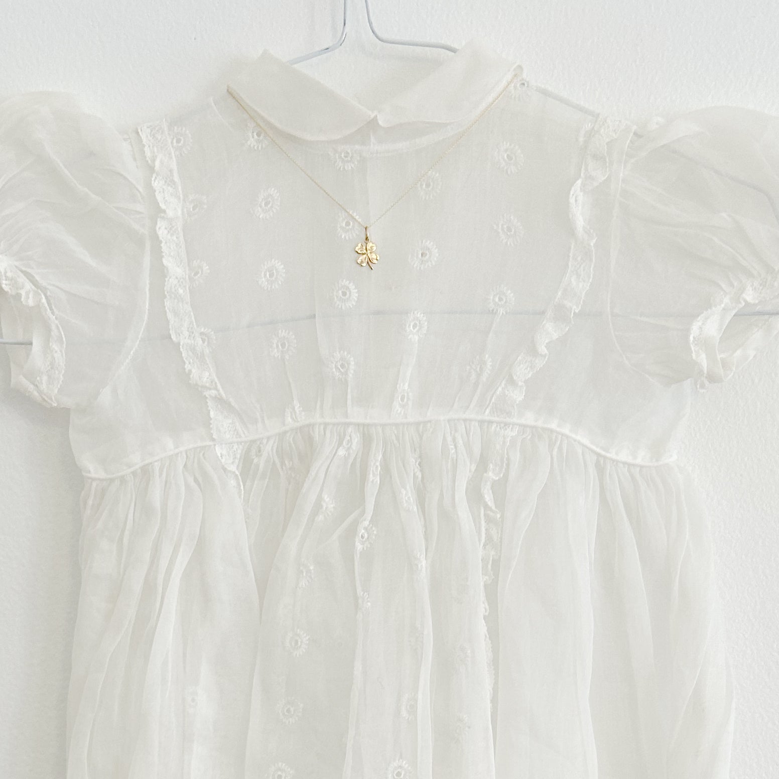 A white dress with a lucky clover gold necklace